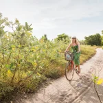 young woman riding a bike on a path