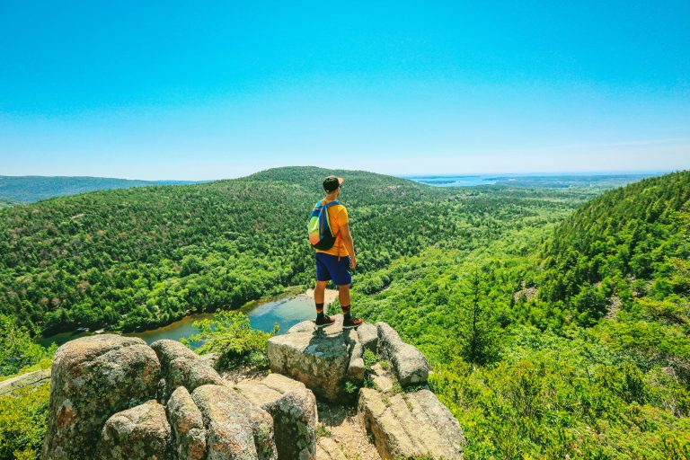man standing on an outcrop in the mountains